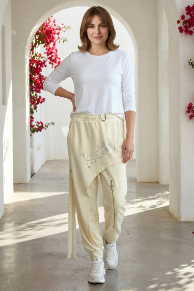 Gelbe Baggy Beautyful mit Straß, asymmetrischer Überwurf mit funkelndem Schriftzug, dekorativer Reißverschluss am linken Bein, elastischer Bund.